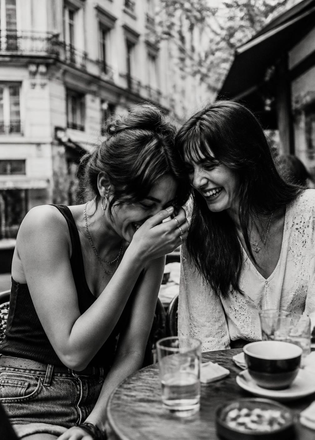 Deux amies complices en terrasse, photographiées en noir et blanc